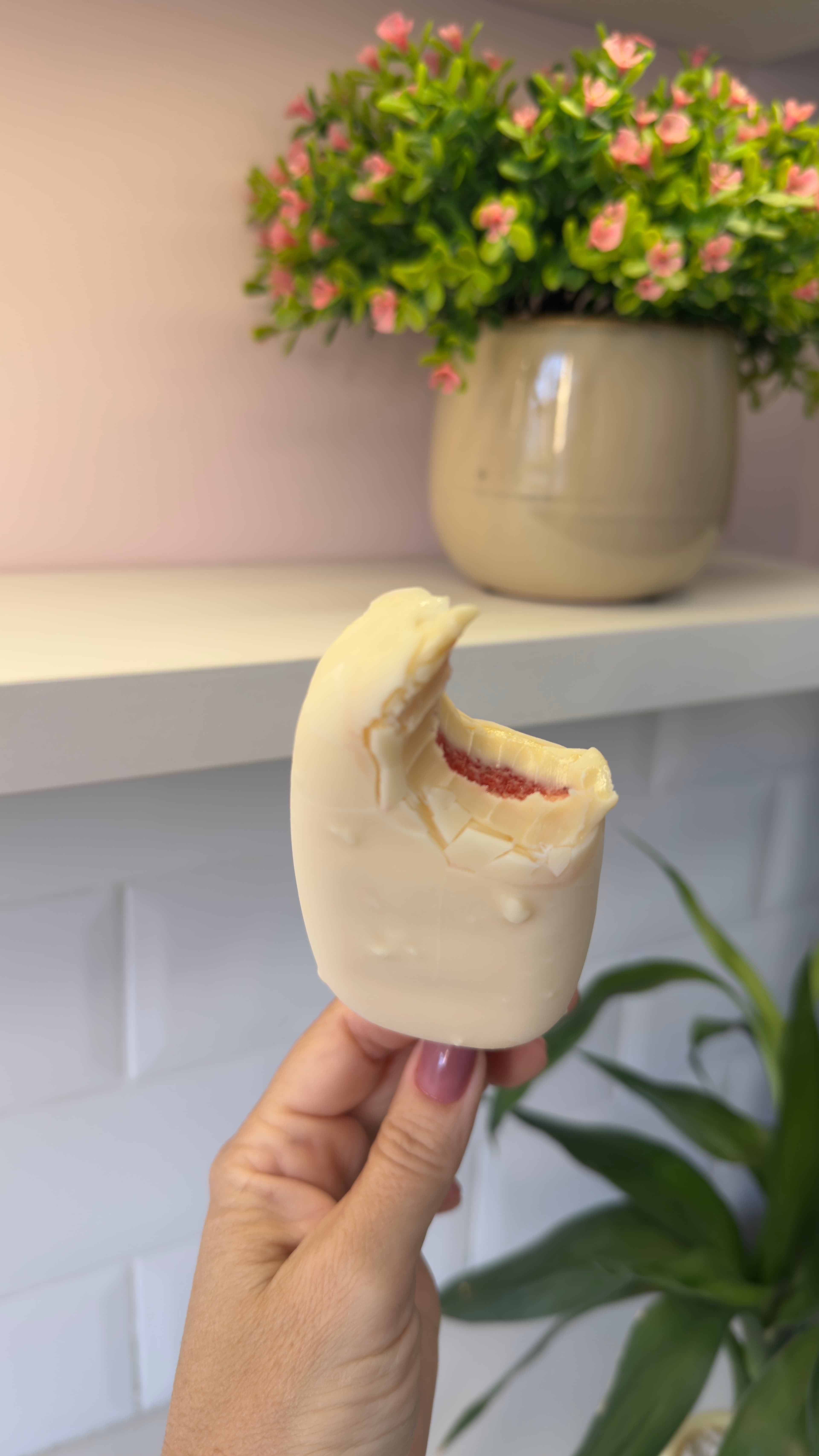 Picolé de chocolate branco mordido mostrando a textura cremosa por dentro